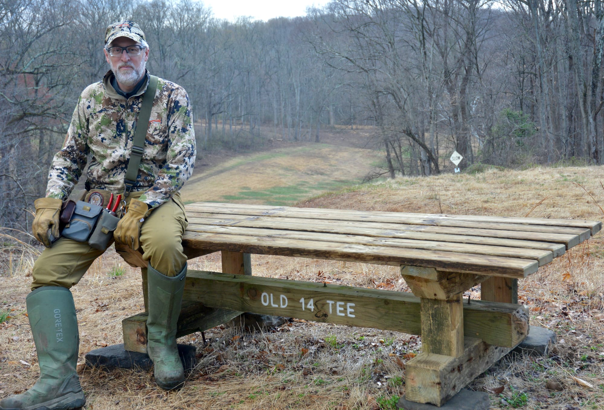 Brian Wright sits on a bench that reads OLD 14 TEE.
