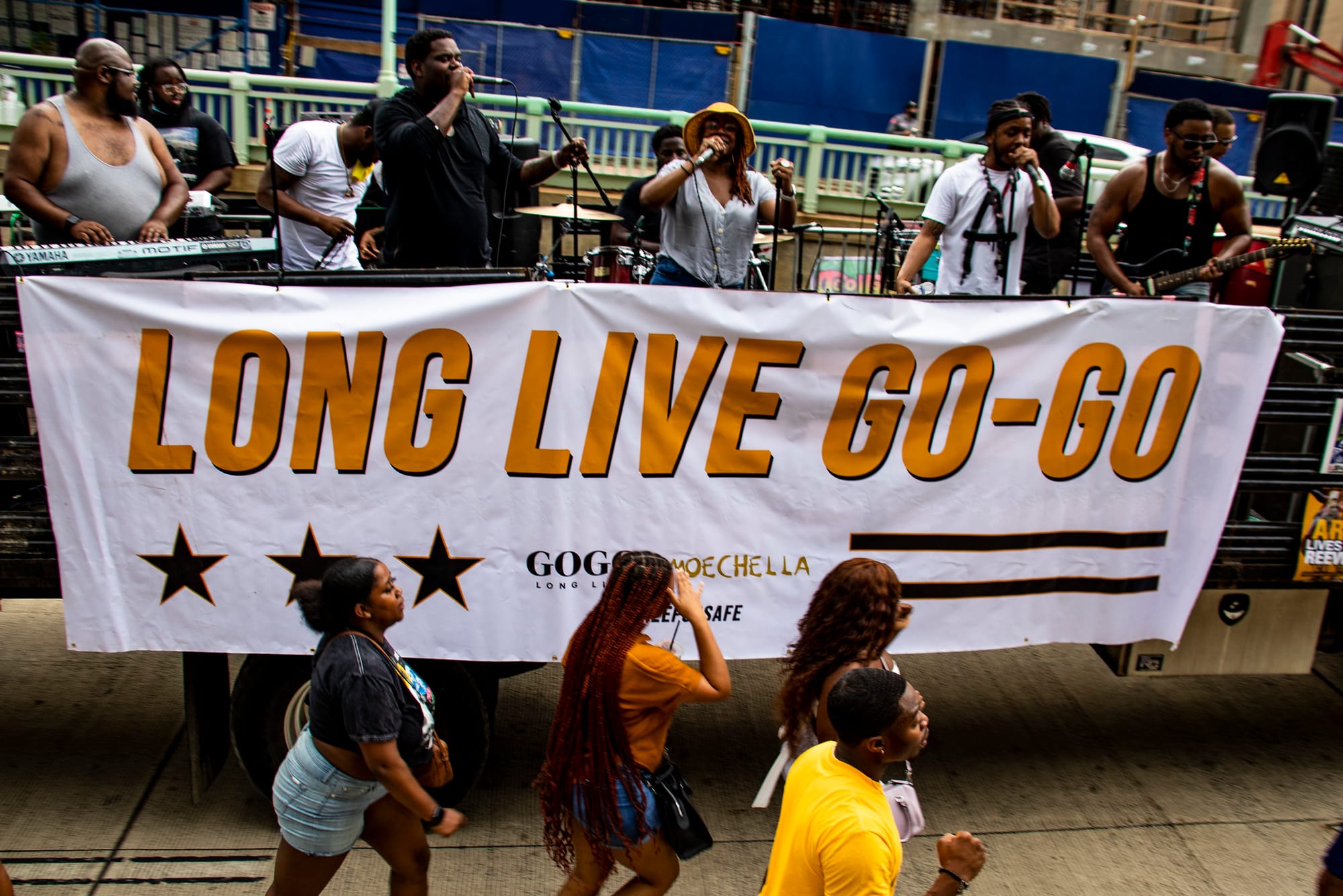 A parade float reads "LONG LIVE GO-GO" on the side