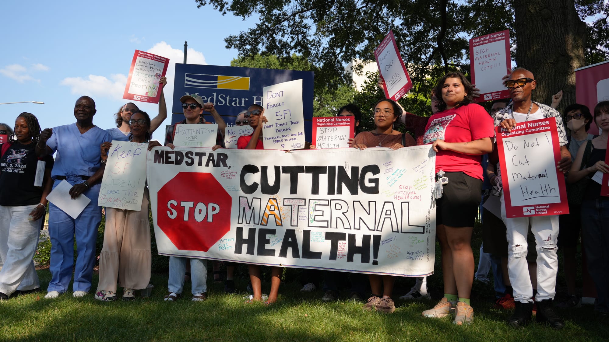 A photo of supporters of the nurses' union and health advocates with a banner that says, "MedStar, stop cutting maternal health!"