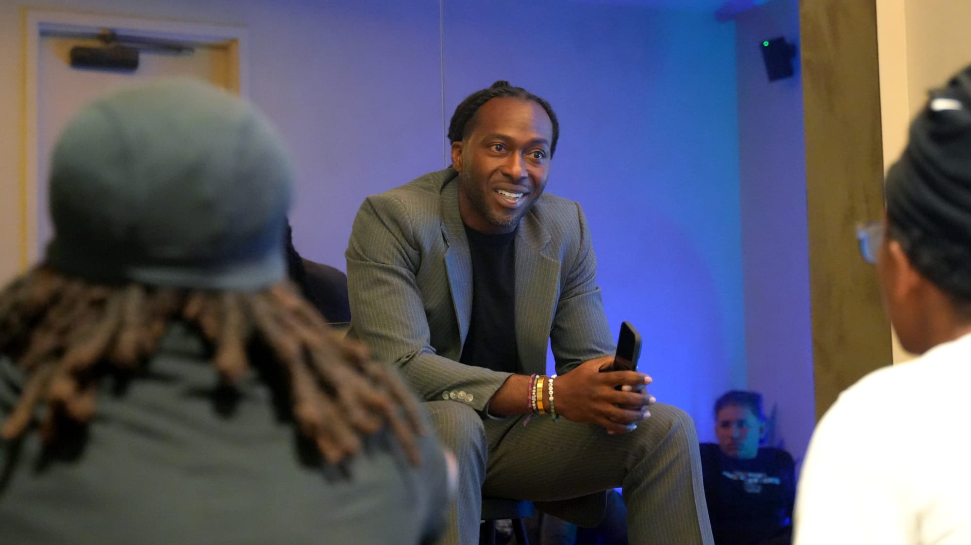 A photo of Patrick Walker-Reese sitting in front of Dunbar students and speaking to them.