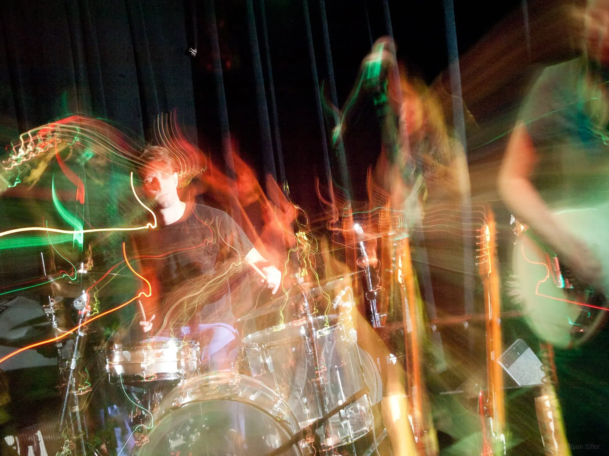 A trippy, distorted picture of a person playing the drums.