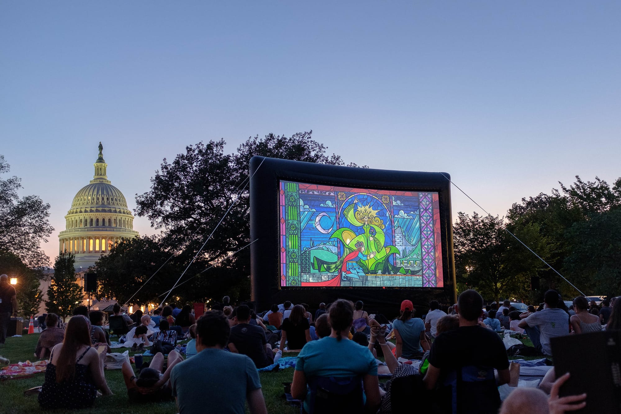 An audience watches an outdoor movie at an inflatable screen outside the U.S. Capitol.
