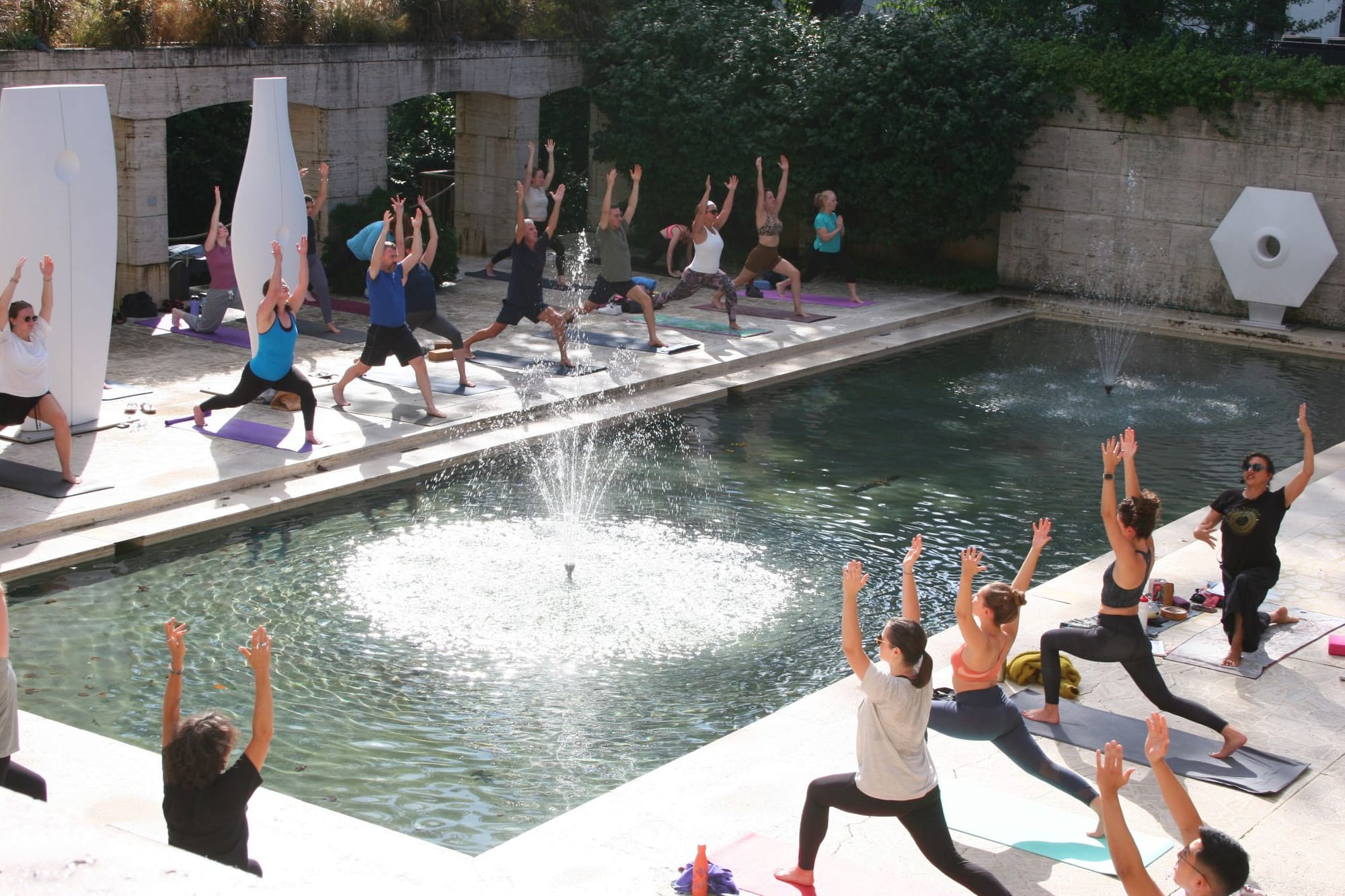 People do yoga around a fountain at the Kreeger Museum.