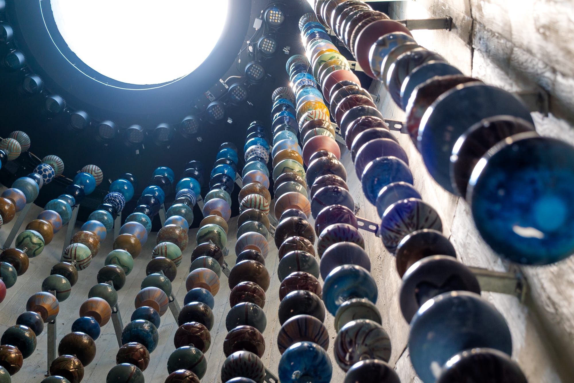 Large ceramic pieces hang from inside the Queen City installation in Arlington.