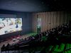 A photograph of a movie theater during a screening at the Palestinian Film Festival packed with attendees.