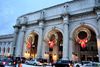 Photo of Union Station in DC with three large, lit wreaths hanging. 
