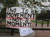 A sign saying This Is a Movement Not a Moment hanging on a gate in Washington, D.C. 