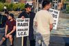 Protesters in Columbia Heights hold signs that read "Stop the raids, abolish ICE"