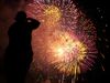 Fireworks and figure of person taking a photo