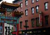 Chinatown arches slightly out of frame next to a red brick building. 