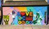  Colorful mural that says Love DC Go-Go with a man dancing on the left and Congress Heights Metro marker on the right
