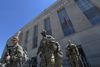 Photo showing uniformed soldiers standing outside of a building labeled "Joint Force Headquarters, District of Columbia National..."