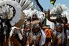 Women adorned in festive carnival wear parading in the street. 