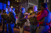 Five officers wearing HSI vests and one wearing an FBI vest stand on a D.C. street in the evening. 