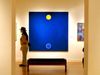 A person in a hat stands in front of an abstract painting at The Phillips Collection in D.C. — "Blue Spell" by Thomas Downing
