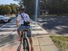 A person on a bike waits for a light to change to cross the street. 