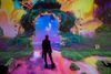 A person stands in a colorful, fanciful art installation.