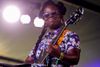 Guitarist Yasmin Williams plays on stage at an outdoor music festival.