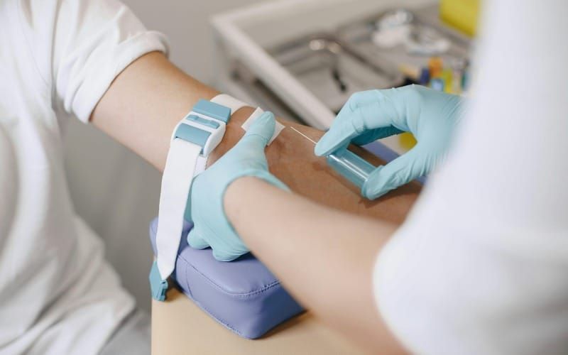 임상병리실에서 진공채혈관으로 환자를 채혈하는 사진