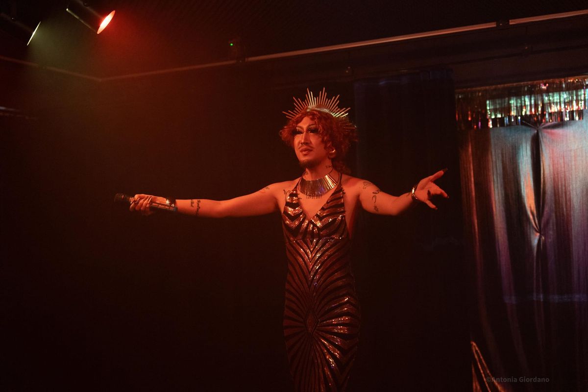 Drag Queen Hurricane Kimchi dressed as Queen Esther in a gold and black striped dress as Hakehillah Korea's Purim Spiel.