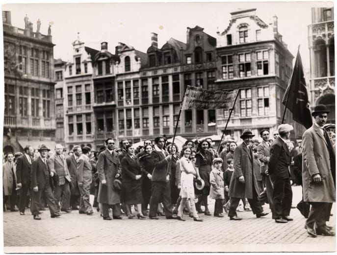 Black-and-white image of men and women marching with banners in a Bundist rally in Belgium in 1935..