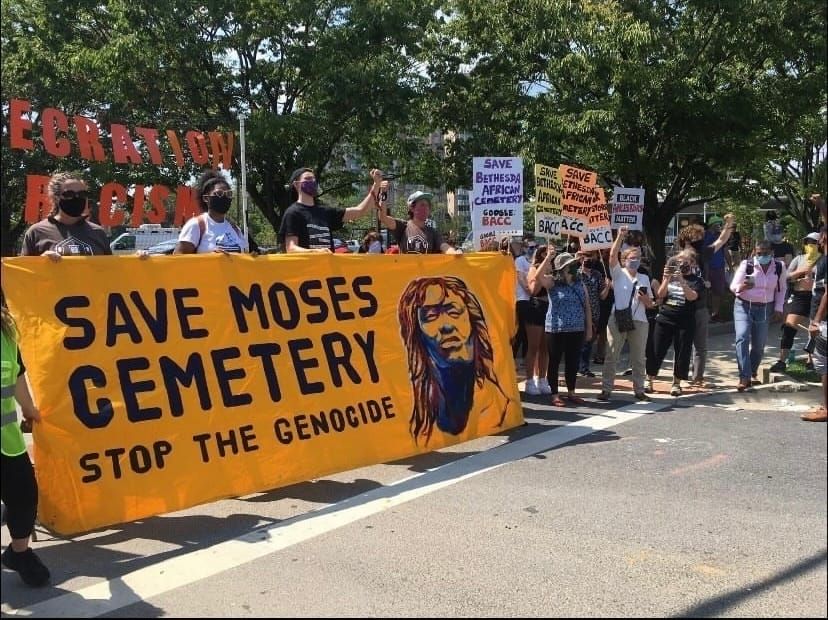 Crowd at demonstrations holding Save Moses Cemetery - Stop the Genocide banner & BACC support signs