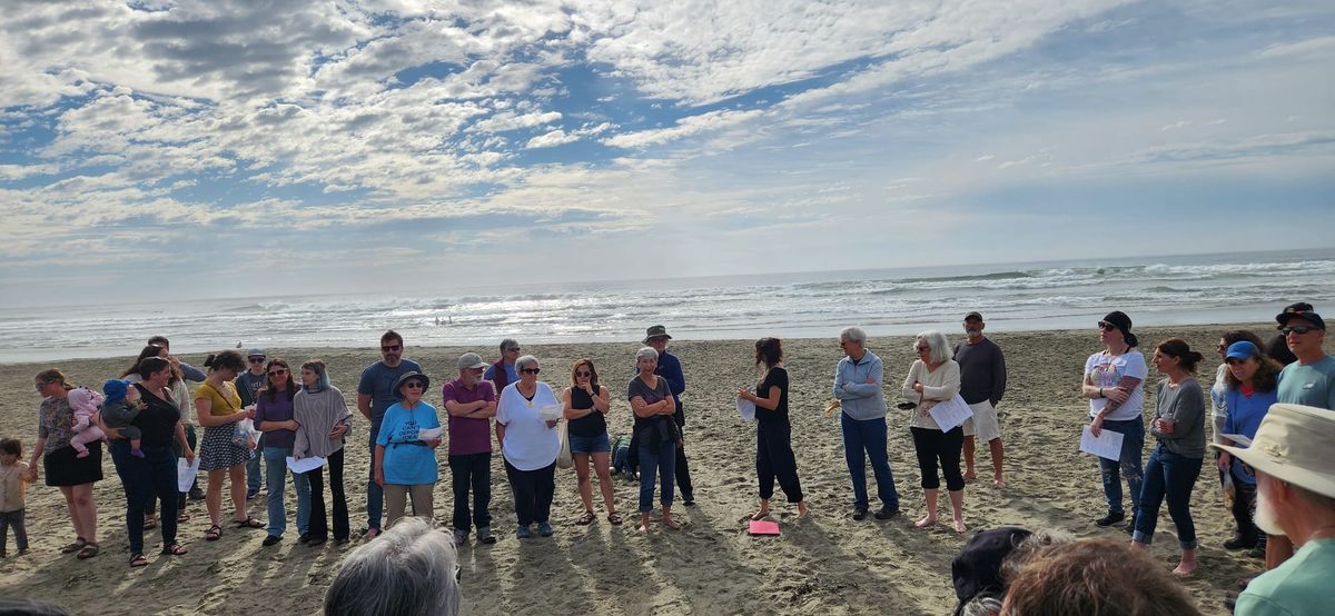several dozen Jews standing on the beach during a Tashlich service in San Franci