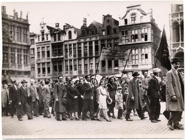 Black-and-white image of men and women marching with banners in a Bundist rally in Belgium in 1935..