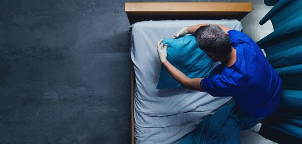 Healthcare worker doing on bed in hospital, coronavirus concept.