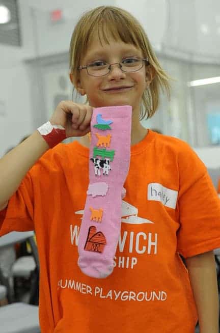 Hailey Muller shows off her newly decorated sock created during craft time at the WMC this week.[Whitney Neilson / The Observer]