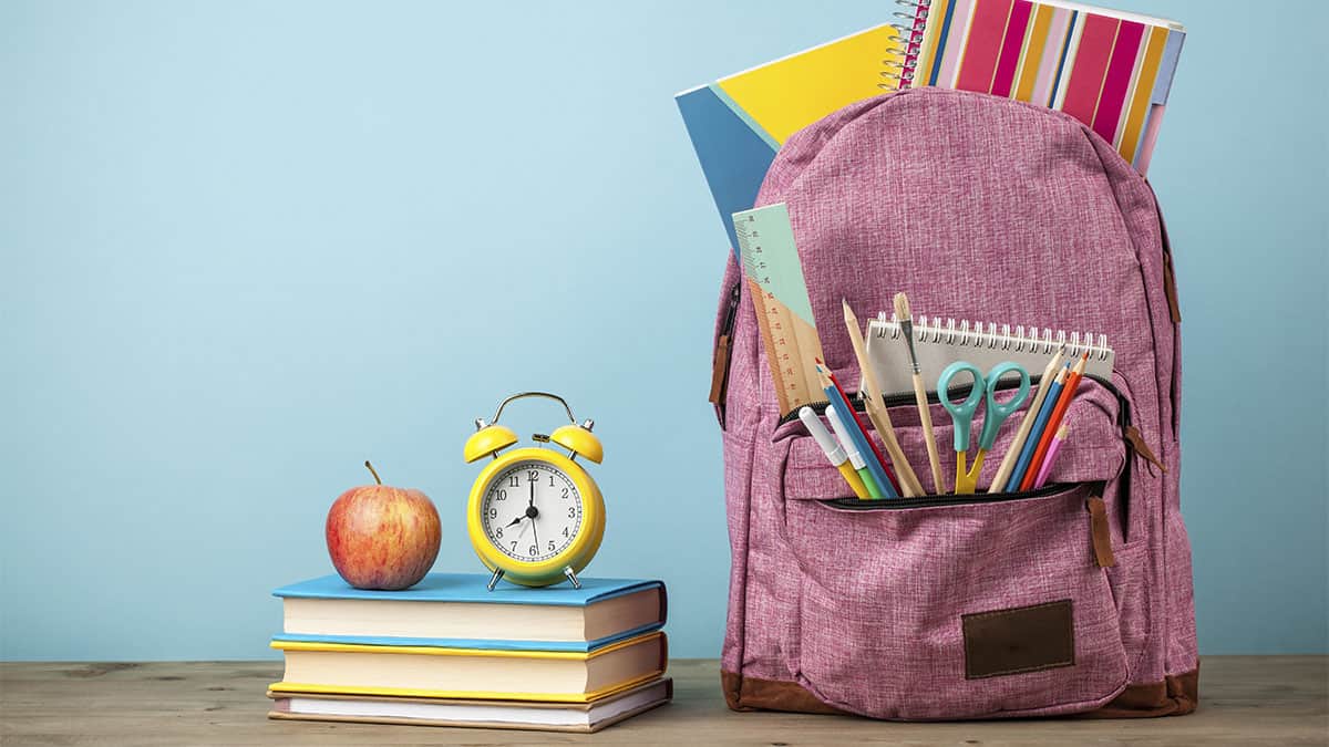 Working to stuff backpacks for students back to school