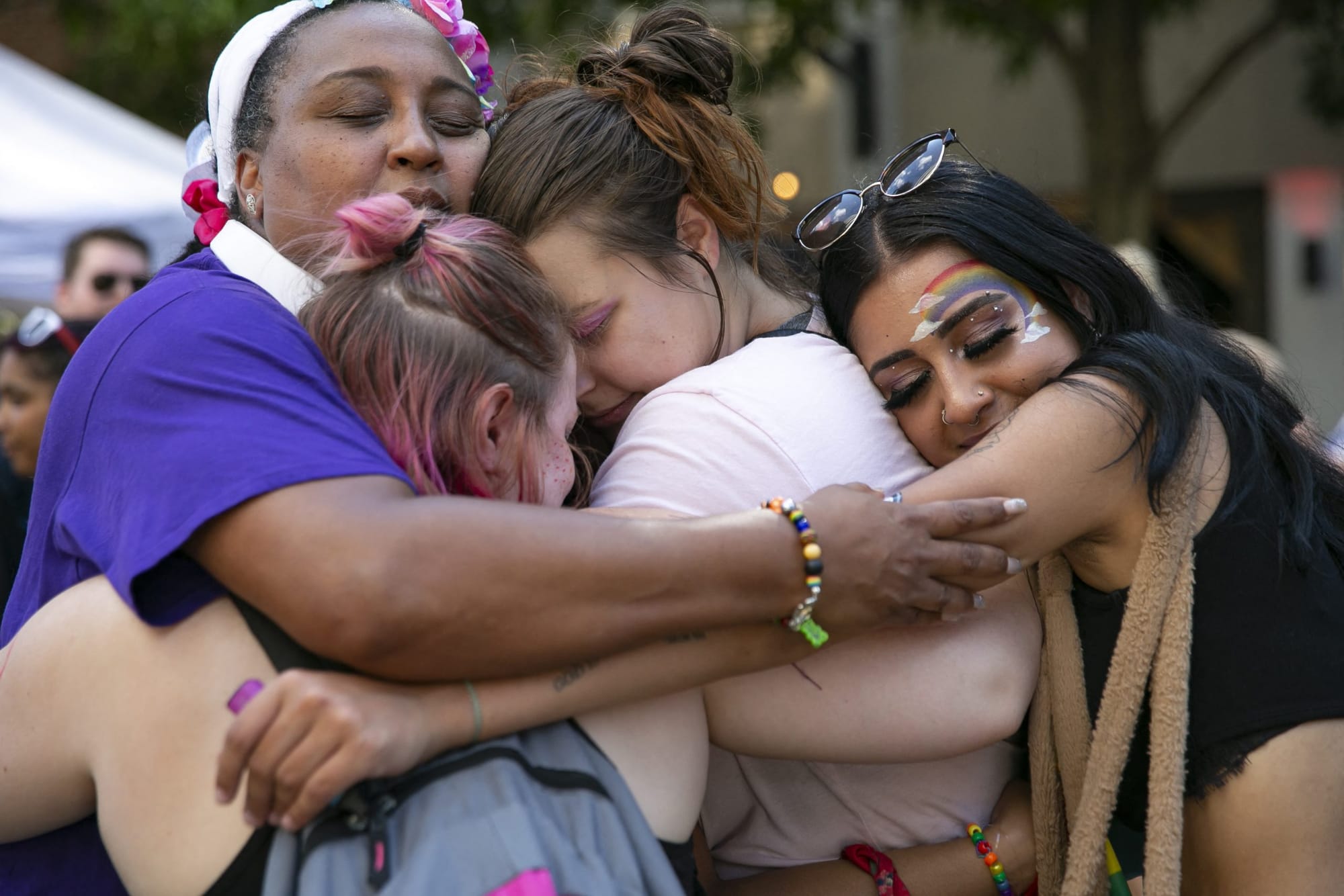 color photograph of a group of queer youth embracing