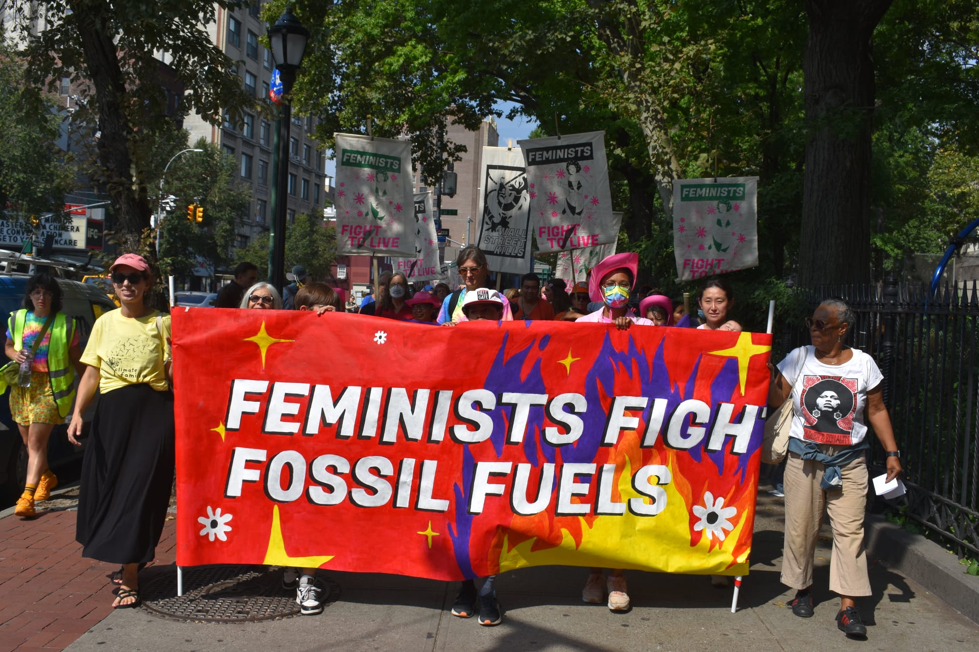Protesters hold a banner that says "Feminists fights fossil fuels."