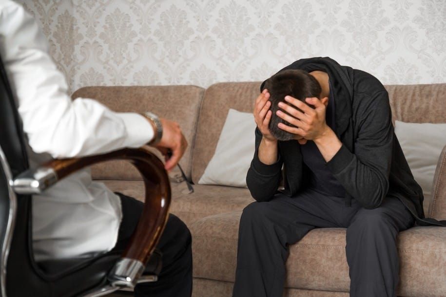 young-man-is-sitting-on-couch-and-covers-face-with-hands-in-the-psychologist-office_t20_eVV13K.jpg