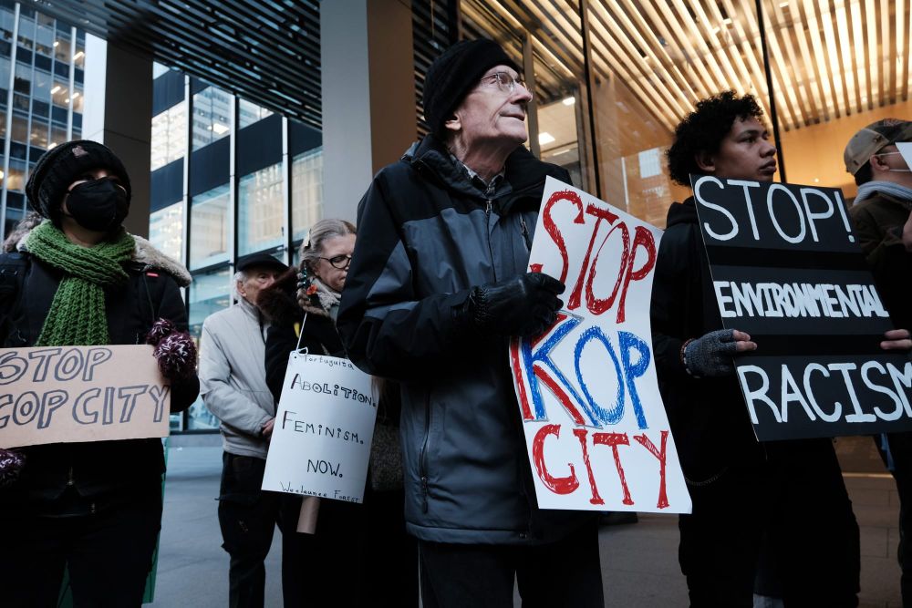 color photograph of an outdoor protest in New York City against Cop City in Atlanta. people wearing black and grey coats hold