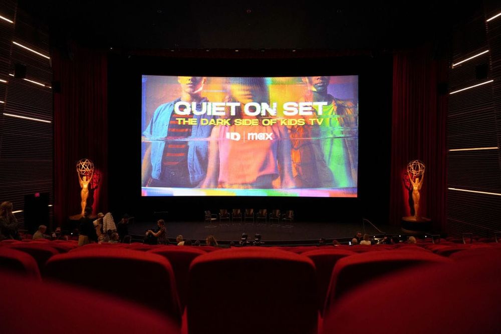 photograph of a movie theater with screen reading "Quiet on Set"