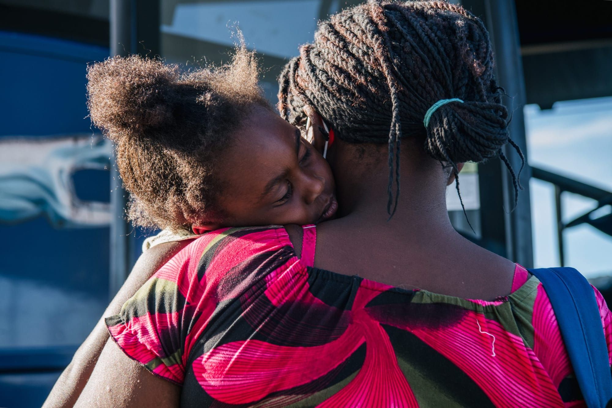 a black woman asylum-seeker holds her daughter