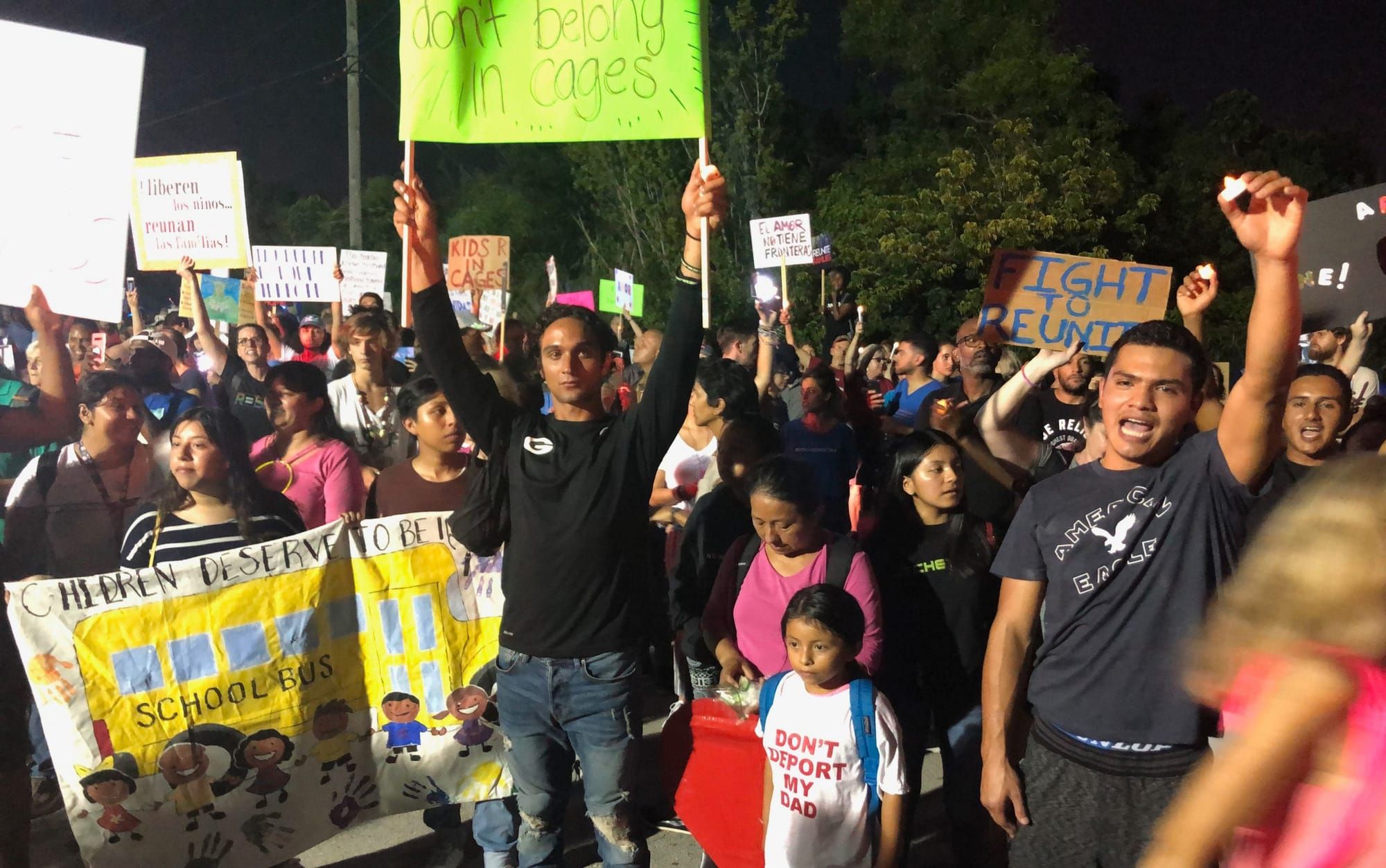 People hold signs during a rally to close immigrant detention centers.