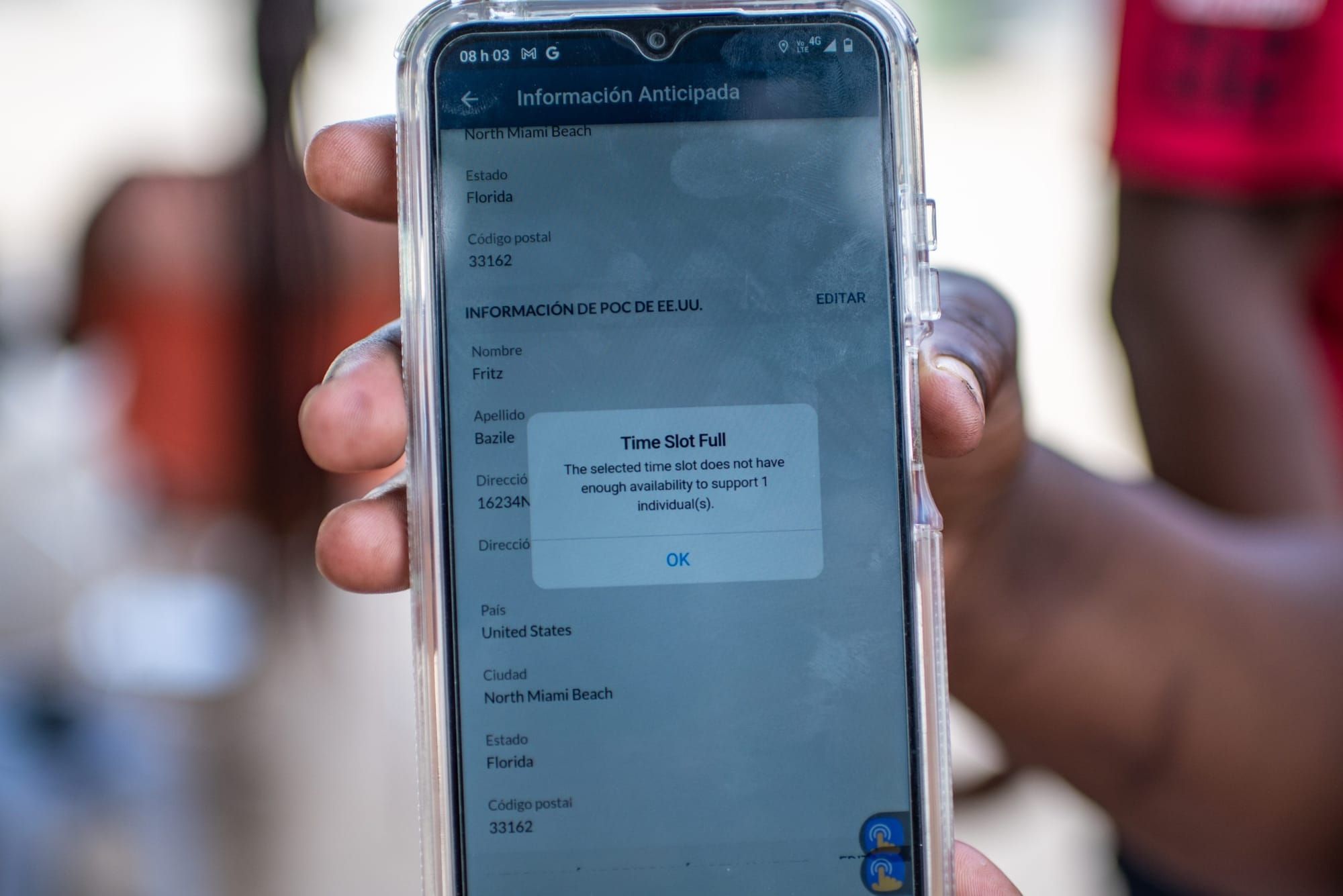 color photograph of a Black person's hand holding a smartphone screen close to the camera. On the phone screen is a pop-up re