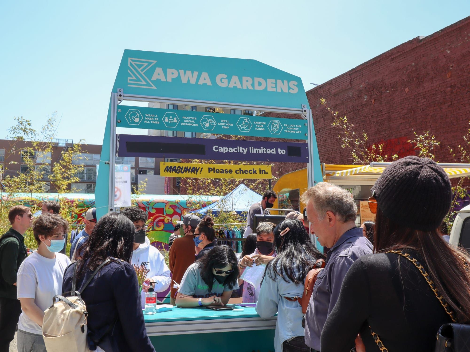 color photograph of a light blue booth outdoors with with text across the top reading "kapwa gardnes"
