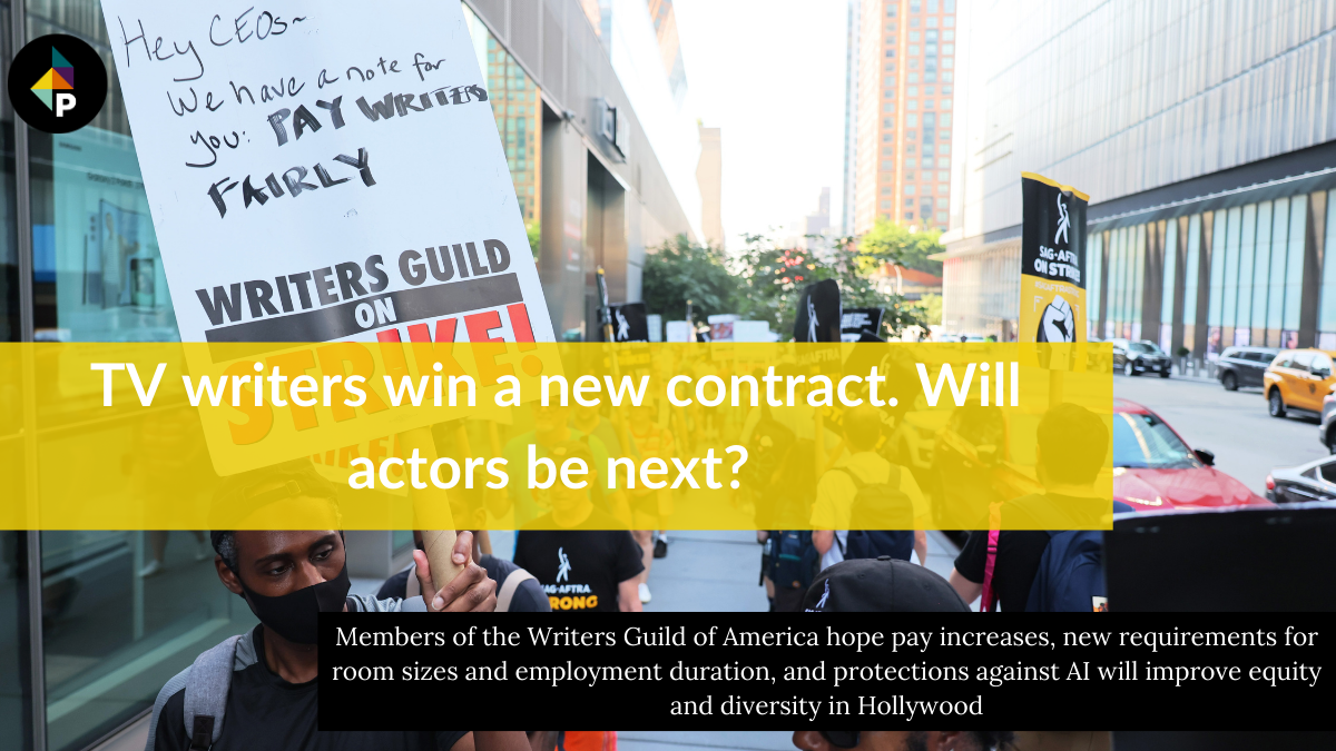 color photograph of an outdoor protest on an urban sidewalk. people hold up picket signs in support of WGA and SAG-AFTRA. in