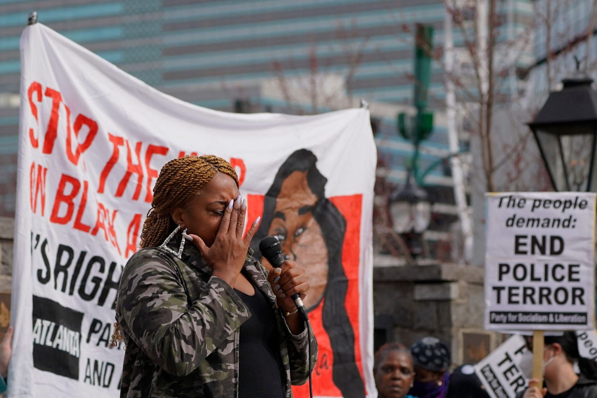 color photograph of a Black woman at an outdoor protest against police violence in response to police killing Tyre Nichols. p