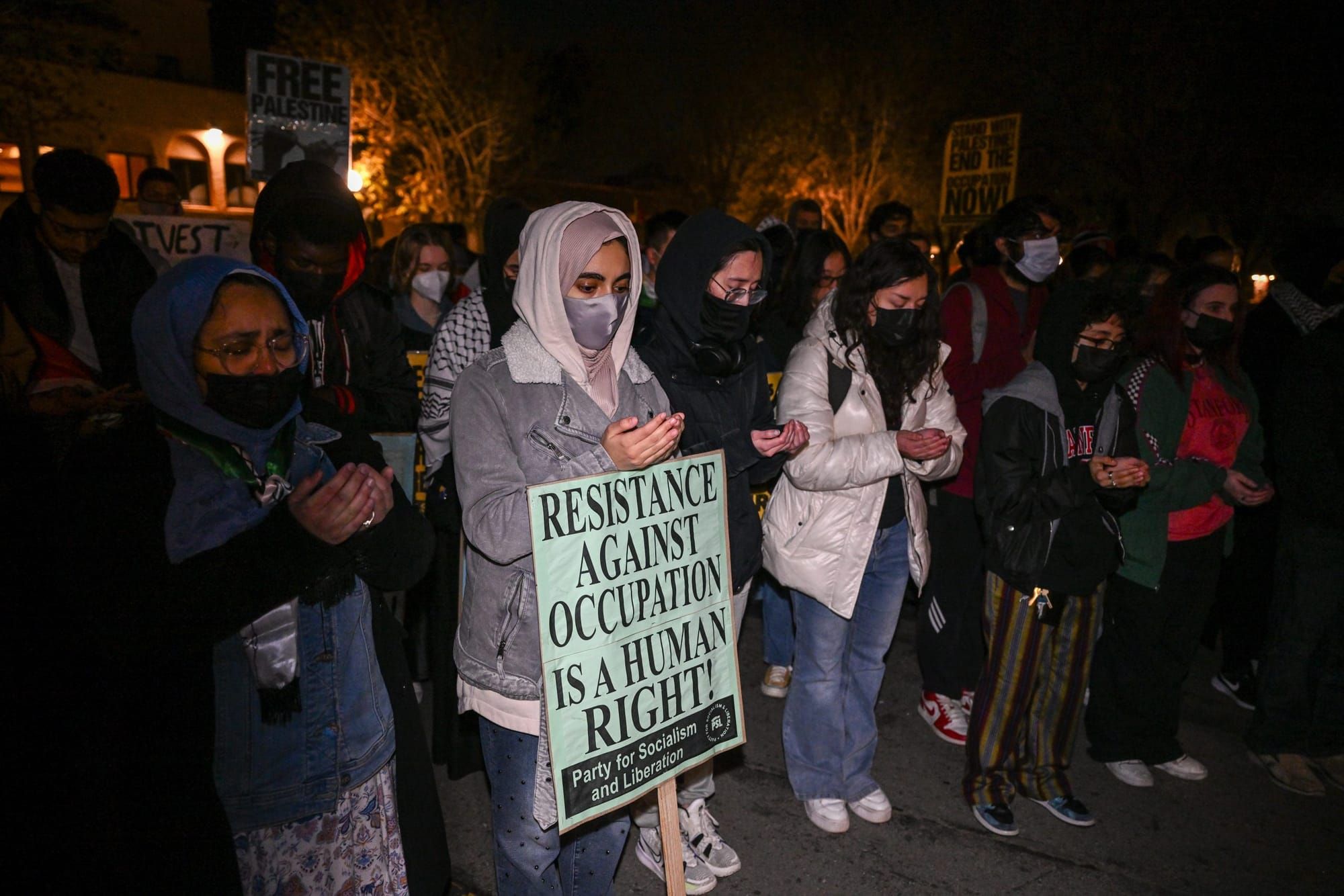color photograph of a nighttime outdoor protest in support of Palestinian liberation
