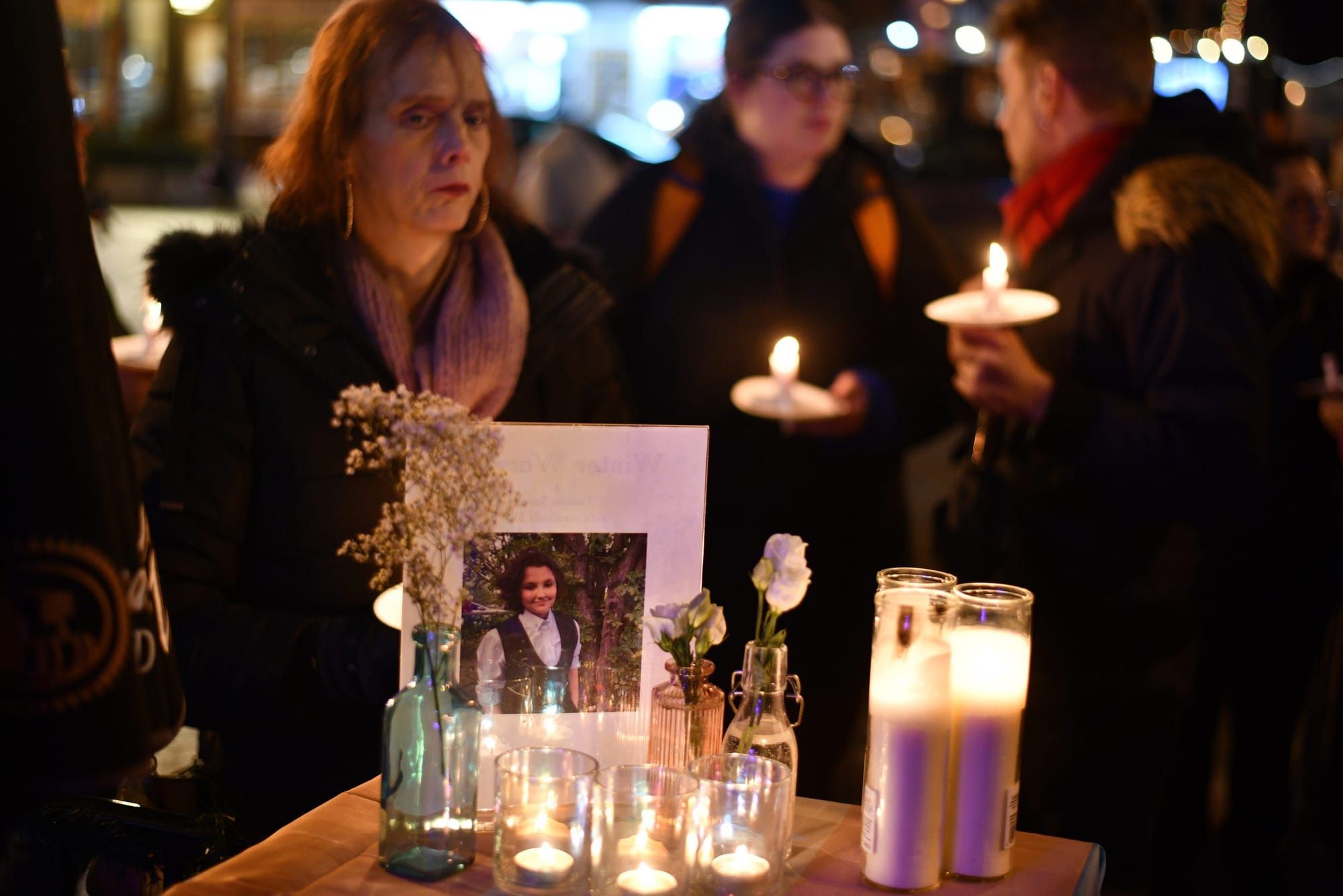 color photograph of an evening memorial for Nex Benedict. a photo of the teenager is surrounded by candles