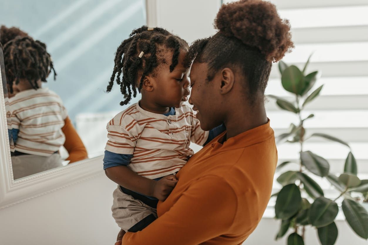 color stock photo of a Black mother holding her infant son