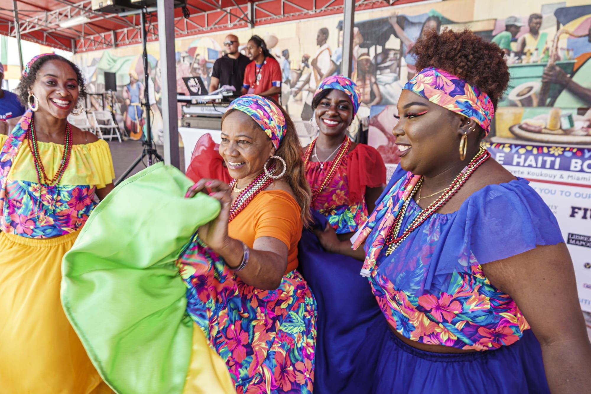 color photograph of four Afrolatine women in colorful dresses at an outdoor festival