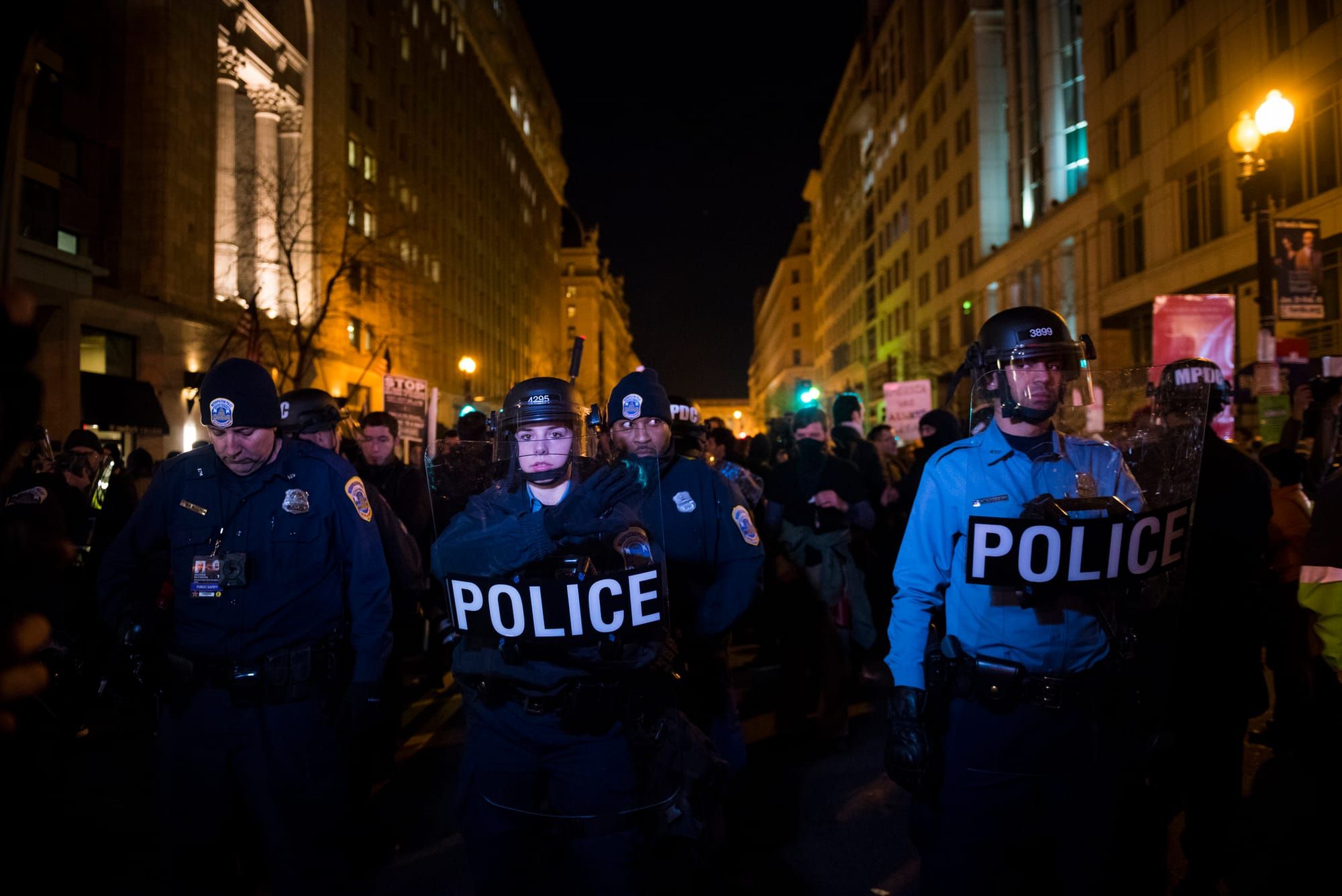 color photograph of police lined up on a dark street at night