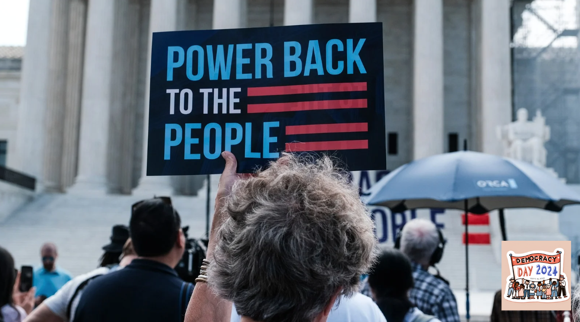 photograph of protest with a person holding a sign that reads "power back to the people"