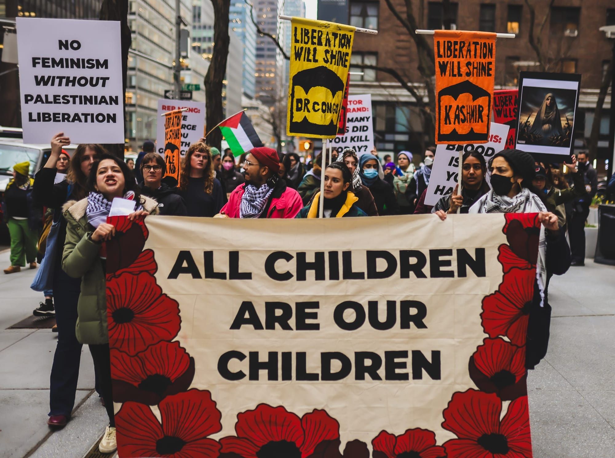 Protesters hold a banner reading "All children are our children"