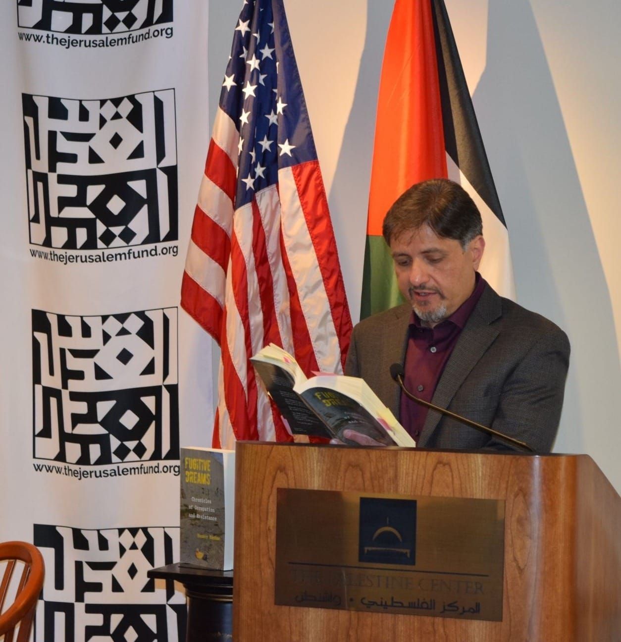 Ramsey Hanhan stands at a podium reading from his book